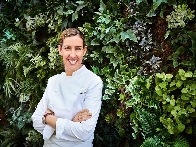 Clare Smyth steht vor einer grünen Hecke  clare-smyth-aus-london