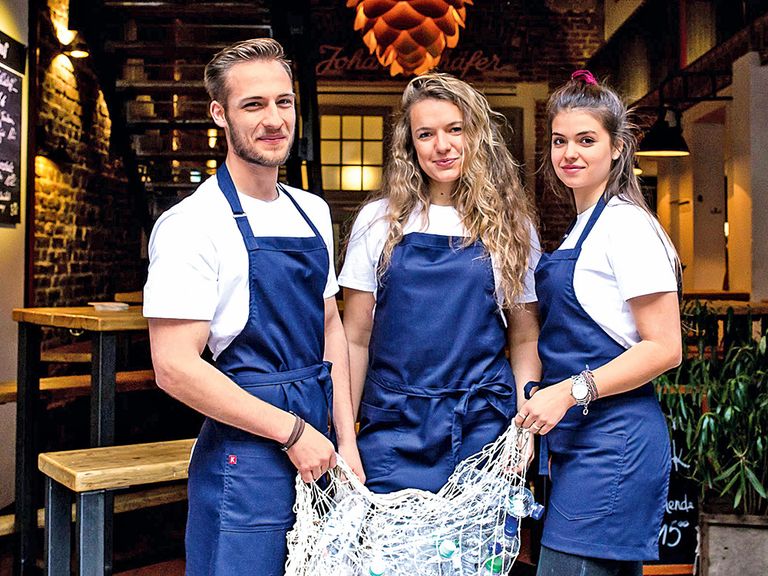 Drei Menschen tragen die Kochschürzen aus dem Meer von Kaya&Kato kochschuerzen-aus-dem-meer-no-waste