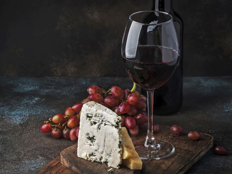 Ein Glas Portwein samt Flasche neben Trauben und Blauschimmelkäse (Stillleben). portwein