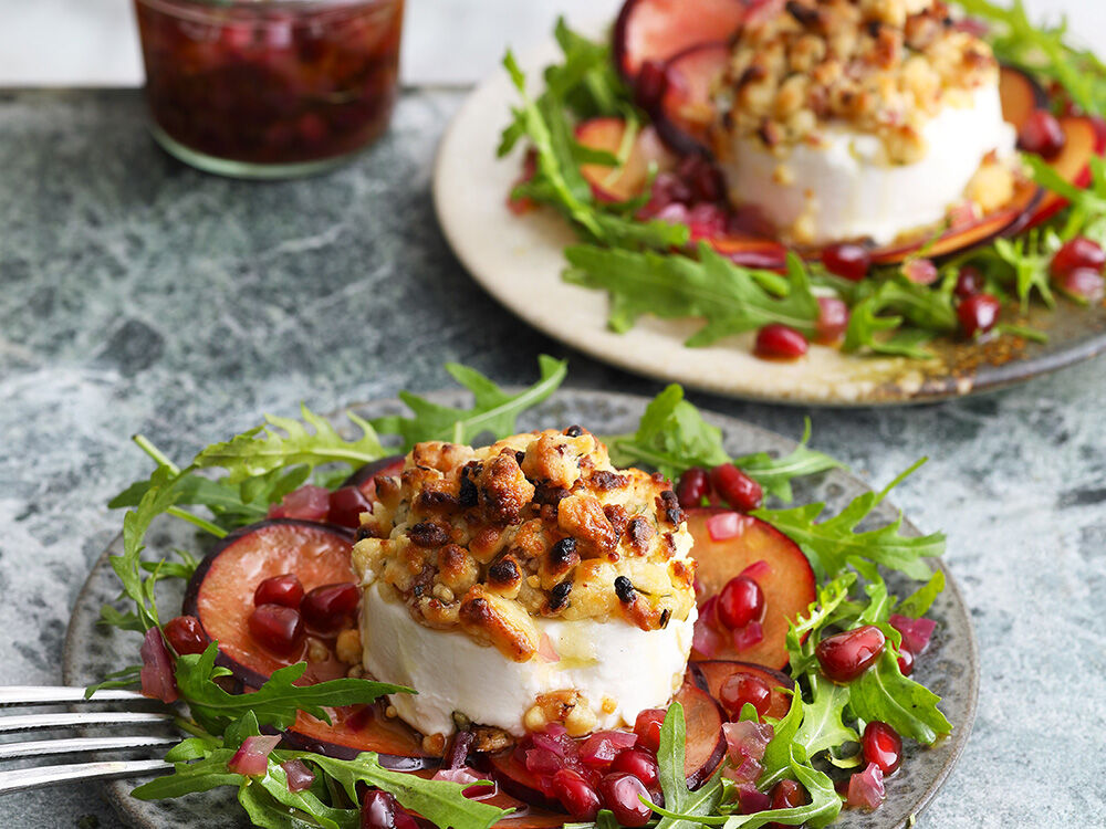 Ziegenkäsetaler mit Honig-Speck-Crumble auf Rucola mit Granatapfel-Dressing und Pflaumen-Carpaccio