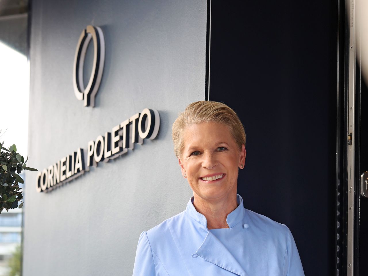 Spitzenk&ouml;chin Cornelia Poletto im Kochjackett vor ihrem Restaurant