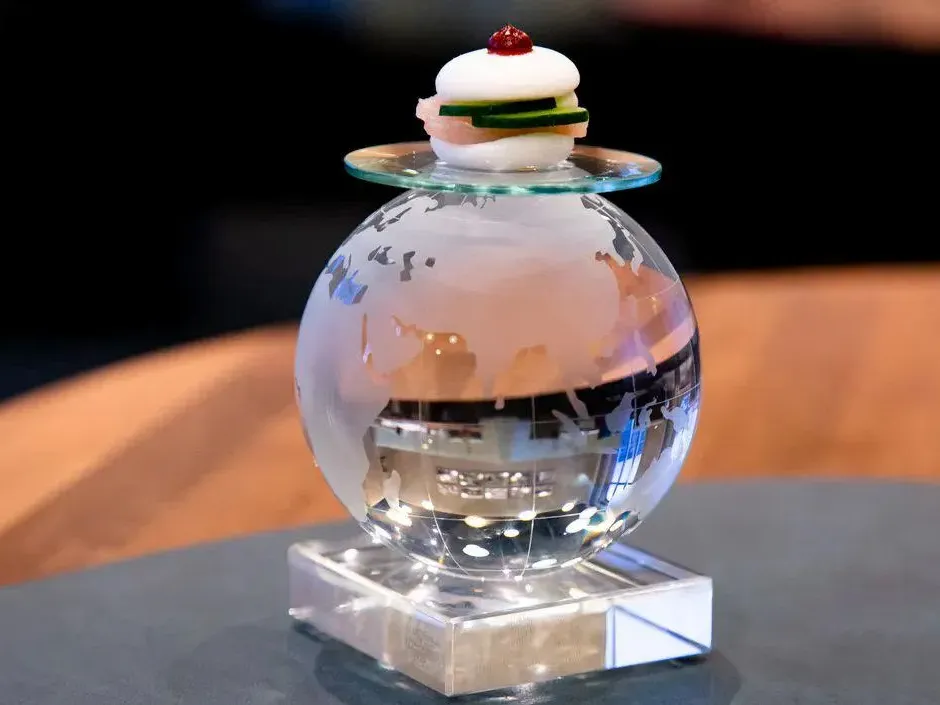 Fischbr&ouml;tchen von Kevin Fehling auf einer gl&auml;sernen Weltkugel im THE GLOBE an Bord der EUROPA von Hapag-Lloyd Cruises.