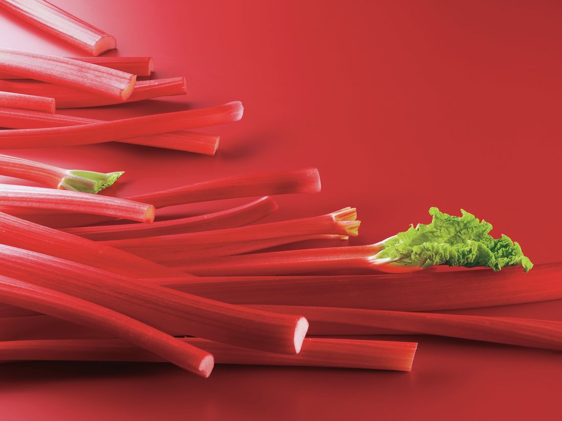 Rhabarberstangen_liegen_auf_rotem_Untergrund